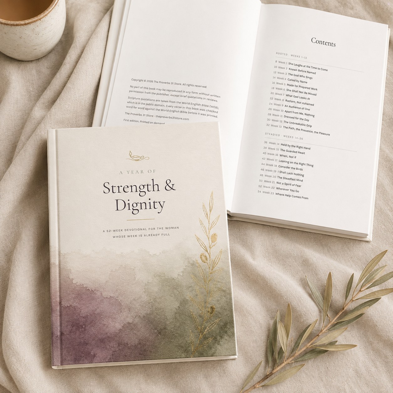The devotional open to its contents page beside a cup of coffee on linen